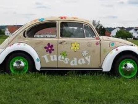 Photo of VW beetle with the word Tuesday and flowers painted on it
